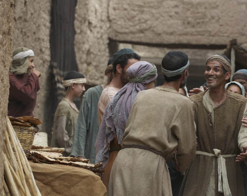 A man greets his friend smiling in the streets of a Jerusalem market