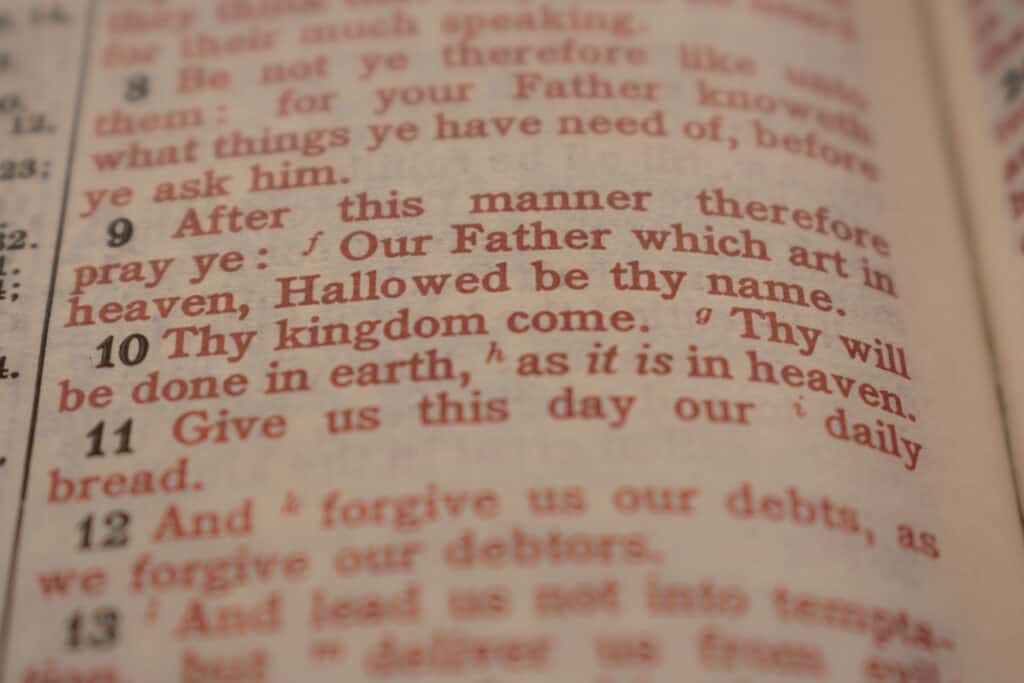 Zoomed in on the Bible chapter and verse of Jesus' words in red, describing how to pray the Lord's prayer.